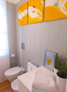 巴勒摩的住宿－Gebel Grin，一间带卫生间的浴室和墙上的绘画作品