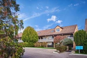 a building with a parking lot in front of it at Kyriad Direct Epinal in &Eacute;pinal