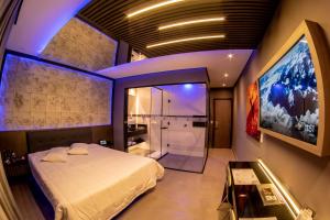 ein Schlafzimmer mit einem Bett und einer ebenerdigen Dusche in der Unterkunft Motel Belle (Adult Only) in São Paulo