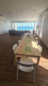 a conference room with a long wooden table and chairs at Casa Del Mar Villa in As Sīfah