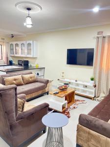 sala de estar con 2 sofás y TV de pantalla plana en Hibiscus Apartments, en Ndola