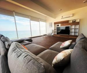 a living room with a couch and a flat screen tv at Casa Del Mar Villa in As Sīfah