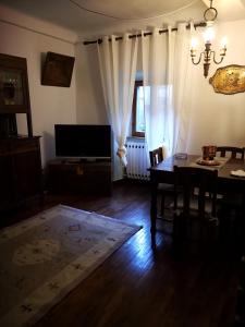 Sala de estar con mesa de comedor y TV en Casa Vacanze CAROLE, en Fivizzano