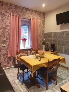 uma cozinha com uma mesa com uma toalha de mesa amarela em Ferienwohnungen lemberg em Hagen