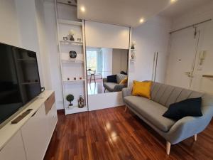 uma sala de estar com um sofá e uma televisão em Studio à 2 pas de la gare em Sartrouville