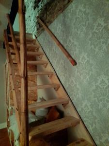 een houten trap in een kamer met een muur bij Les Roches Restaurant & Chambre d'Hotes in Servant