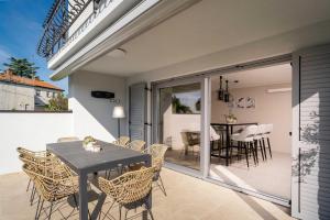 un patio con tavolo e sedie su un balcone di Villa Contessina by SeeAdria Agency a Novigrad Istria
