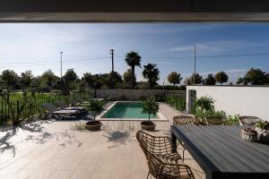 un patio con tavolo e sedie e una piscina di Villa Contessina by SeeAdria Agency a Novigrad Istria