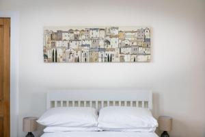 ein Bett mit zwei Kissen und einem Gemälde an der Wand in der Unterkunft Spacious 2 bedroom High Street apartment in North Berwick