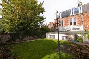 a garden with a table and a bench and a house at Spacious 2 bedroom High Street apartment in North Berwick