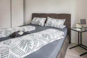 uma cama com um cobertor cinzento e branco e uma mesa em Ferienwohnung Holly em Ebringen
