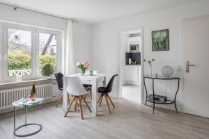 uma sala de estar branca com uma mesa e cadeiras em Ferienwohnung Holly em Ebringen