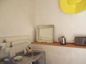 a bathroom with a sink and a mirror on a shelf at La Maison Jasmin in Arles