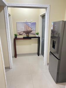 un pasillo con nevera y una foto de un barco en Hibiscus Apartments en Ndola