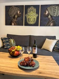 una mesa con un bol de fruta y una botella de vino en Karma, en Kamari