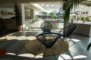 a patio with two chairs and a table and a bar at Seaside Studios in Kavos