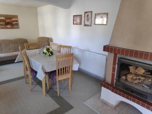 a dining room with a table and a fireplace at Domček Janina in Suchá Hora