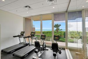 einen Fitnessraum mit Kardiogeräten und einem großen Fenster in der Unterkunft Somerset 203 in Marco Island