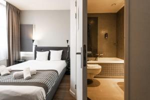 um quarto de hotel com uma cama e uma casa de banho em Acostar Hotel em Amsterdã