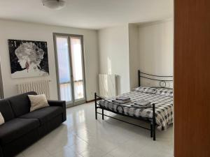 un soggiorno con letto e divano di MIMA House a Bergamo