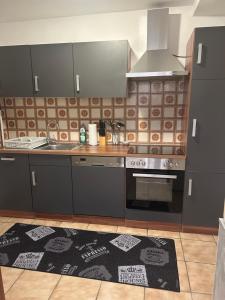 a kitchen with stainless steel appliances and a rug at Ferienwohnung Schwarzwald in Pforzheim