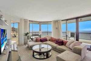 a living room with a couch and a tv and windows at Sandcastle I-1201 in Marco Island