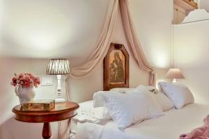 a bedroom with two beds and a table with a vase of flowers at Suite Royal in La Spezia