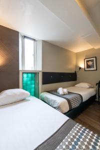 a hotel room with two beds and a window at Acostar Hotel in Amsterdam