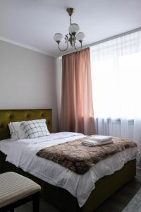 een slaapkamer met een groot bed en een raam bij Aki City Center Apartment in Constanţa
