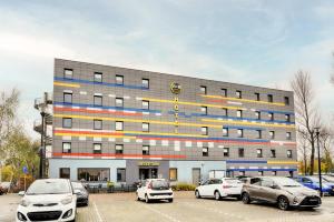 a large building with cars parked in a parking lot at B&B Hotel Amsterdam-Zaandam in Zaandam