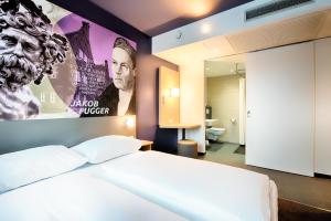 Schlafzimmer mit einem Himmelbett an der Wand in der Unterkunft B&B Hotel Augsburg-West in Augsburg