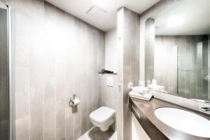 a bathroom with a toilet and a sink at B&B Hotel Aachen-City in Aachen