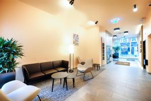 a lobby with a couch and chairs and a table at B&B Hotel Aachen-City in Aachen