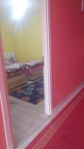 a room with a red door and a room with a bed at Çiftlik otel 