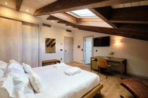a bedroom with a bed and a desk with a computer at HOTEL BOUTIQUE VILLA DEL MARQUÉS in Muros de Nalón