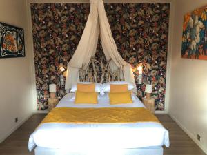 a bedroom with a white bed with yellow pillows at Logis Hôtels Troglododo in Azay-le-Rideau