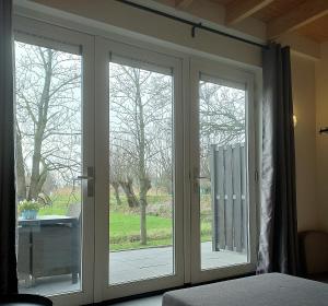 uma sala com duas portas de vidro deslizantes num quarto em Landelijk appartement in een mooi recreatiegebied em Abcoude