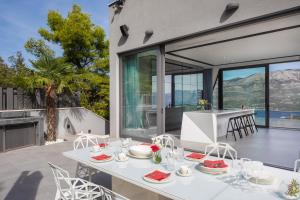 a dining room with a table and chairs on a patio at VILLA DIAMOND in Žrnovo