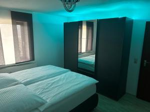 Dormitorio azul con cama y espejo en Ferienwohnung Schwarzwald, en Pforzheim