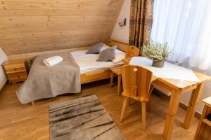 um pequeno quarto com uma cama e uma mesa em APLIT 2 GUEST HOUSE em Zakopane