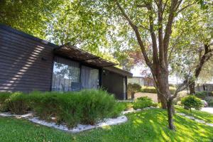 una casa nera con un albero in giardino di Prazer da Natureza Resort & Spa a Caminha