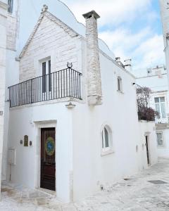 ein weißes Gebäude mit Kamin und Tür in der Unterkunft Suite San Martino in Martina Franca