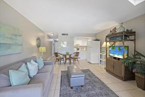 un salon avec un canapé et une télévision dans l'établissement Idyllic inland condo with pool and beach access, à Marco Island