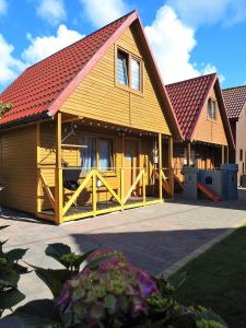 una gran casa de madera con techo rojo en Domki u Skrzata Drewniane, en Łeba