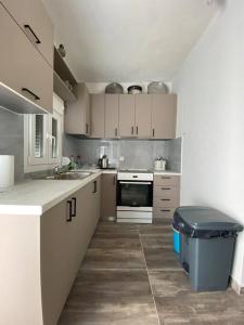 a kitchen with white cabinets and a trash can at Natural Retreat Shelter #Unoblu® in Agriliá