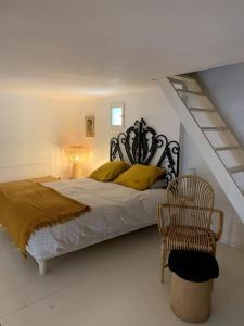 a bedroom with a large bed and a chair at La Maison Jasmin in Arles