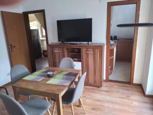ein Wohnzimmer mit einem Holztisch und einem TV in der Unterkunft 1 Zimmer Appartement direkt am Schwielowsee in Neue Scheune