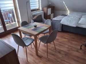 Zimmer mit einem Tisch, Stühlen und einem Bett in der Unterkunft 1 Zimmer Appartement direkt am Schwielowsee in Neue Scheune