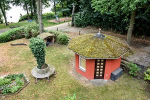 a small house and a bench in a park at 1 Zimmer Appartement direkt am Schwielowsee in Neue Scheune