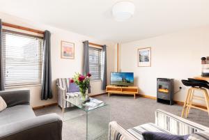 a living room with a couch and a tv at Discovery Accommodation in Whitby